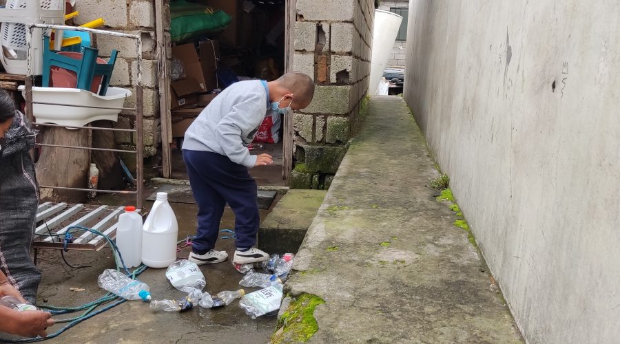 Jesús aplasta las botellas que recogió antes de guardarlas en su bodega